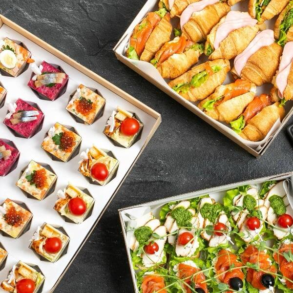 Tre stycken fat på en bordskiva med cateringmat.