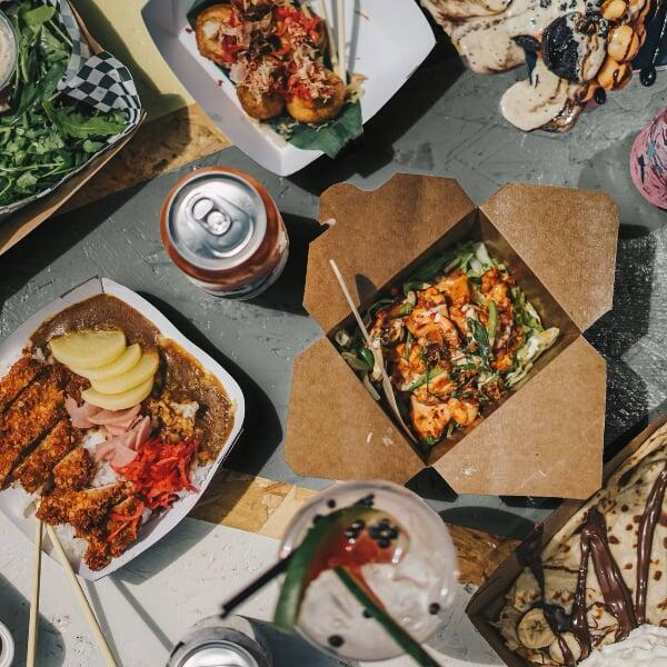 Flera varianter av matlådor och en burk dryck på en bordsskiva.